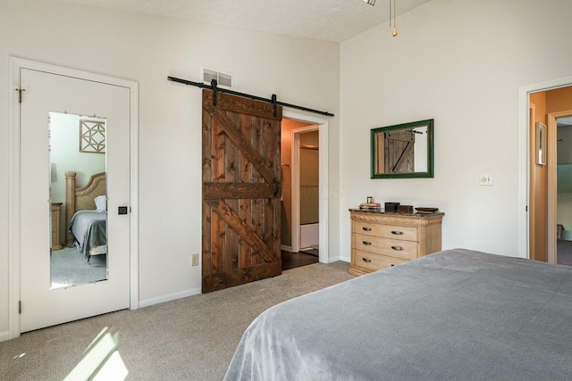 bedroom featuring visible vents, carpet flooring, a barn door, and vaulted ceiling