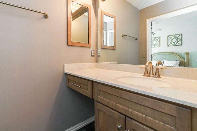 ensuite bathroom with baseboards, ensuite bath, and vanity