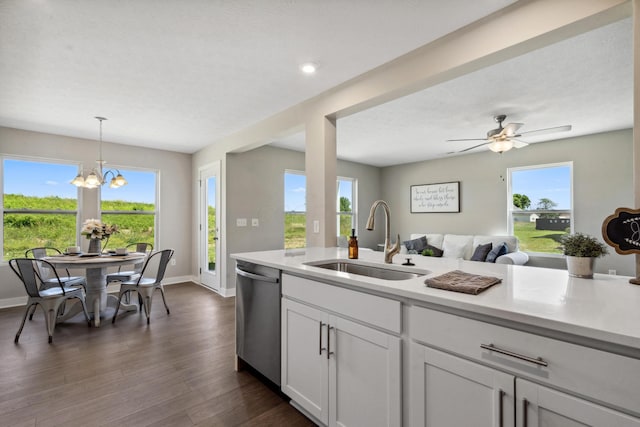 kitchen with open floor plan, dishwasher, light countertops, and a sink