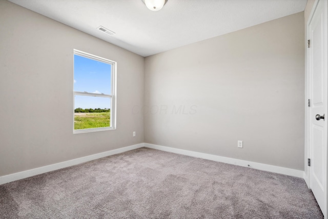 carpeted empty room with visible vents and baseboards