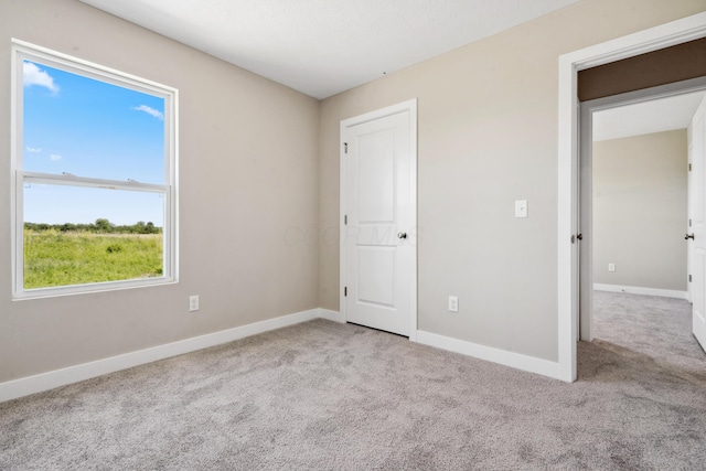 unfurnished bedroom with carpet flooring and baseboards