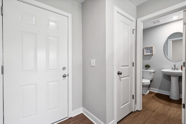 bathroom with visible vents, toilet, wood finished floors, and baseboards