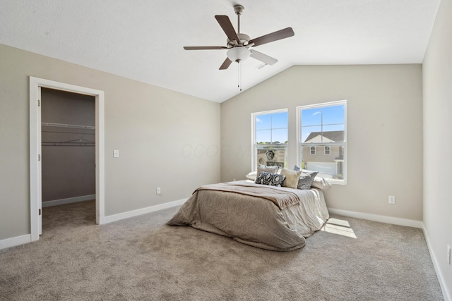 bedroom with baseboards, carpet floors, lofted ceiling, and a spacious closet