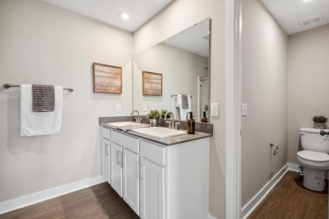 bathroom with visible vents, wood finished floors, and a sink