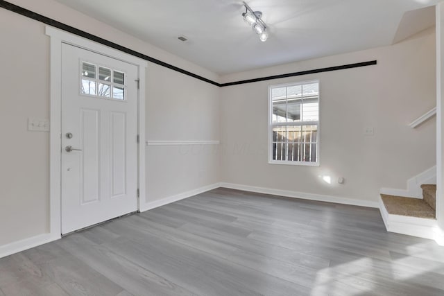 entrance foyer featuring stairway, wood finished floors, and baseboards