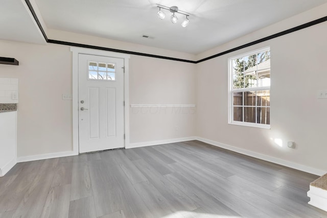 entryway featuring visible vents, baseboards, and wood finished floors