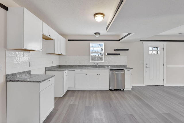 kitchen featuring white cabinets, light wood finished floors, backsplash, and dishwasher