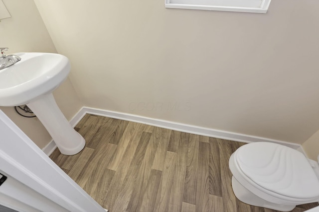 bathroom with baseboards and wood finished floors