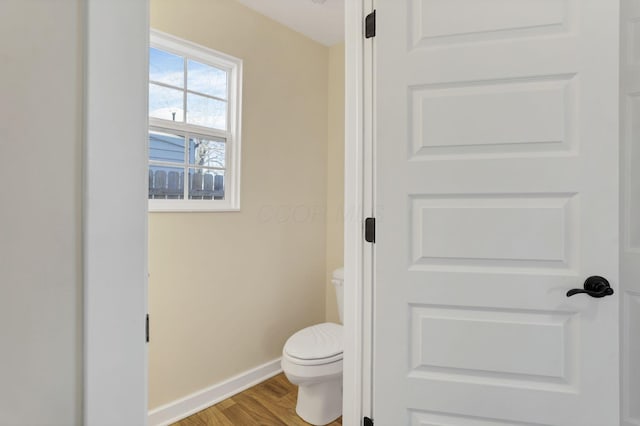 bathroom with baseboards, toilet, and wood finished floors