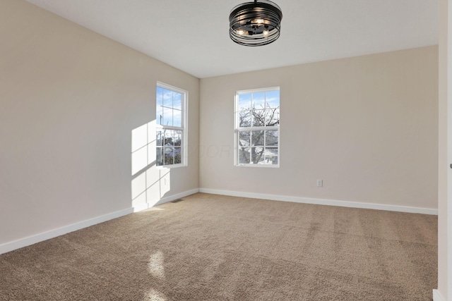 empty room featuring carpet flooring and baseboards