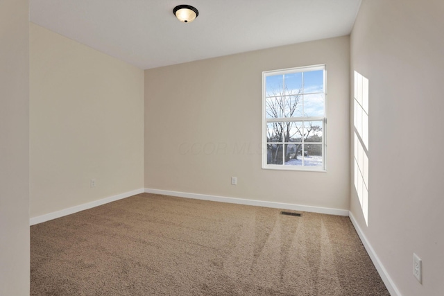 carpeted empty room featuring visible vents and baseboards