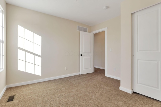 unfurnished bedroom featuring carpet floors, visible vents, and baseboards