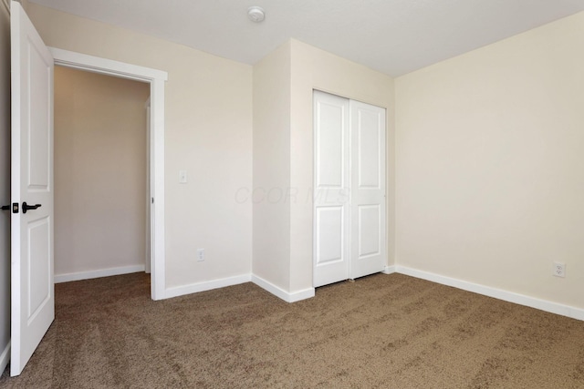 unfurnished bedroom with carpet, baseboards, and a closet