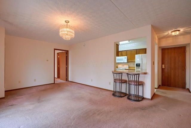 living area with a chandelier, light colored carpet, and a textured ceiling