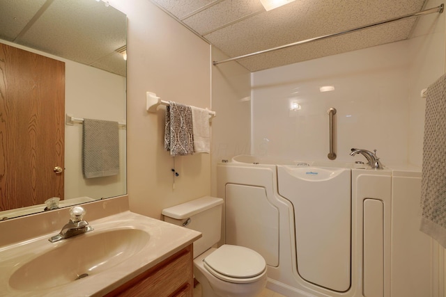 full bathroom featuring toilet, a paneled ceiling, vanity, walk in shower, and a bathtub