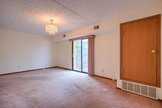 unfurnished room featuring light carpet, baseboards, visible vents, and a chandelier