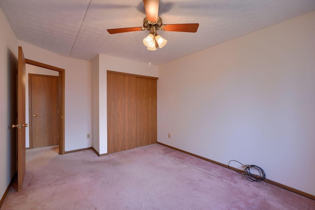 unfurnished bedroom featuring baseboards, ceiling fan, a textured ceiling, carpet flooring, and a closet