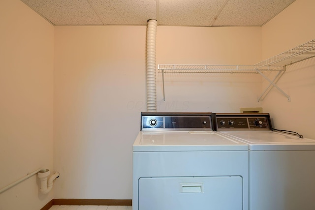 washroom featuring laundry area, washing machine and dryer, and baseboards