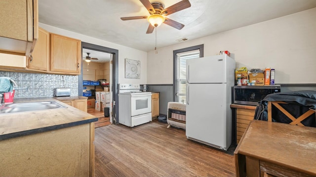 kitchen featuring white appliances, wood finished floors, a sink, backsplash, and light brown cabinetry