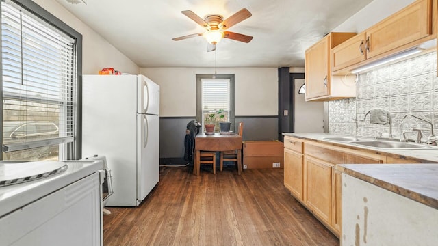 kitchen featuring dark wood-type flooring, light brown cabinetry, a sink, and freestanding refrigerator