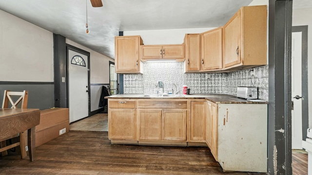 kitchen featuring light brown cabinets, a sink, a ceiling fan, backsplash, and dark wood finished floors