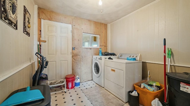 laundry area with washer and dryer, laundry area, wainscoting, and wooden walls