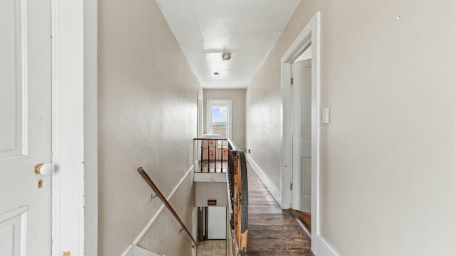 hall featuring baseboards and an upstairs landing