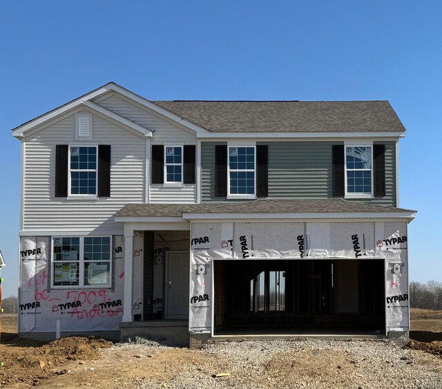 view of front facade with a garage and roof with shingles