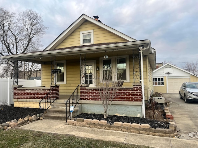 bungalow-style house with an outbuilding, covered porch, and fence