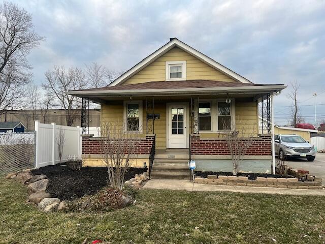 bungalow-style house featuring a porch and fence