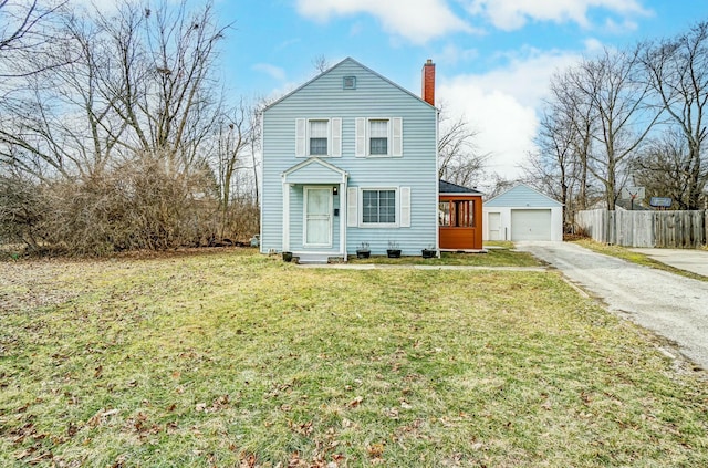 traditional-style home with a chimney, aphalt driveway, an outbuilding, fence, and a front yard