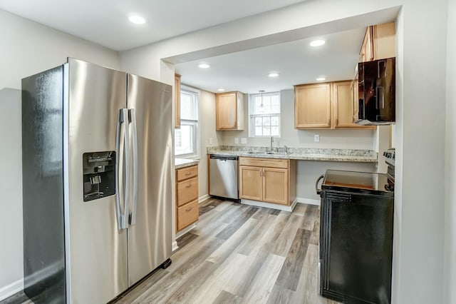 kitchen featuring light brown cabinets, recessed lighting, stainless steel appliances, a sink, and light wood-style floors