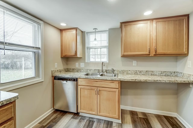 kitchen featuring dishwasher, light brown cabinetry, wood finished floors, and a sink