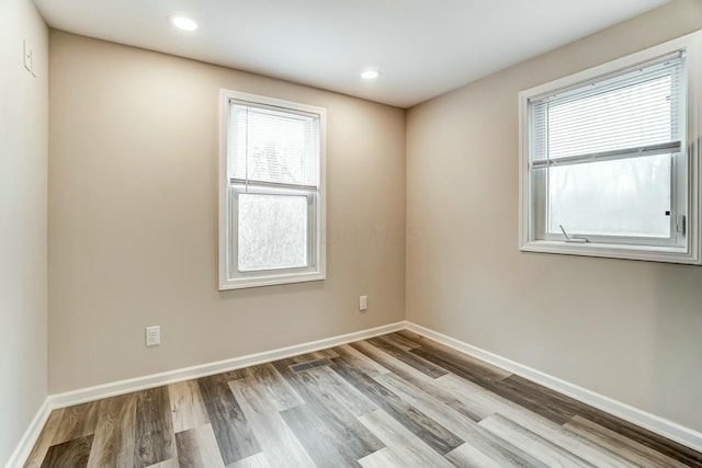 unfurnished room featuring visible vents, baseboards, wood finished floors, and recessed lighting