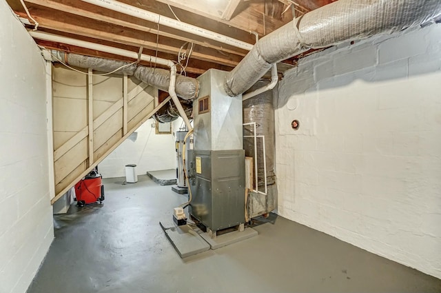 unfinished below grade area with heating unit, gas water heater, and concrete block wall