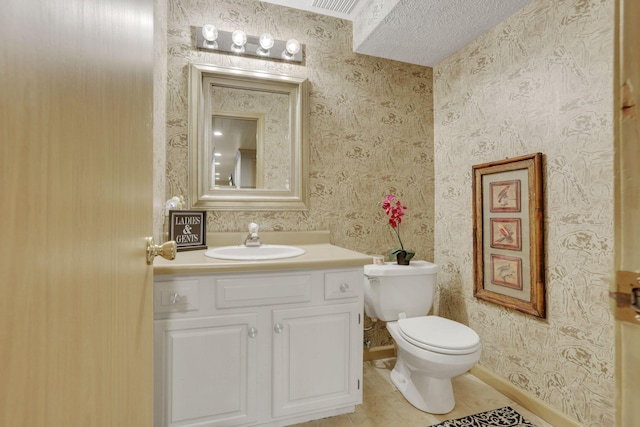 bathroom featuring toilet, vanity, tile patterned flooring, baseboards, and wallpapered walls