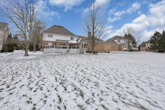 view of snow covered back of property