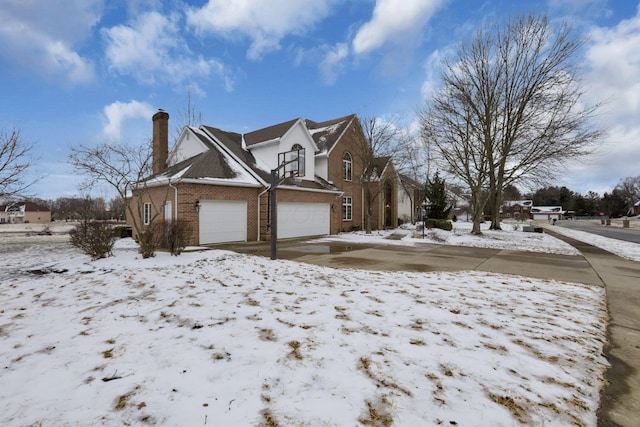 view of snow covered exterior featuring brick siding and a chimney