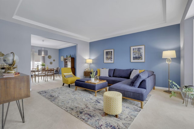 carpeted living room with baseboards and crown molding