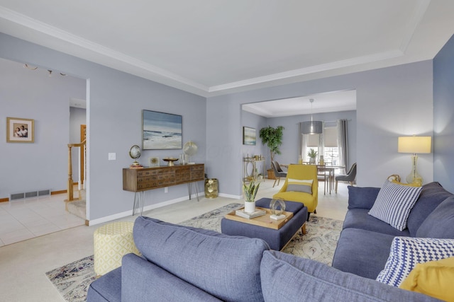 living area featuring baseboards, visible vents, and crown molding