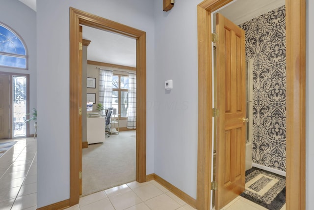 interior space with light carpet, baseboards, and light tile patterned floors