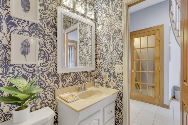 bathroom featuring toilet, wallpapered walls, tile patterned floors, and vanity