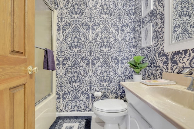 bathroom with toilet, tile patterned floors, vanity, and enclosed tub / shower combo