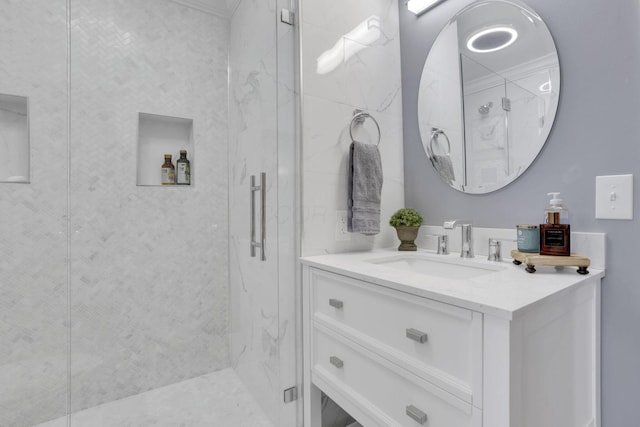 full bath featuring a marble finish shower and vanity