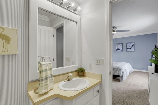 bathroom featuring ensuite bathroom, ceiling fan, vanity, baseboards, and ornamental molding