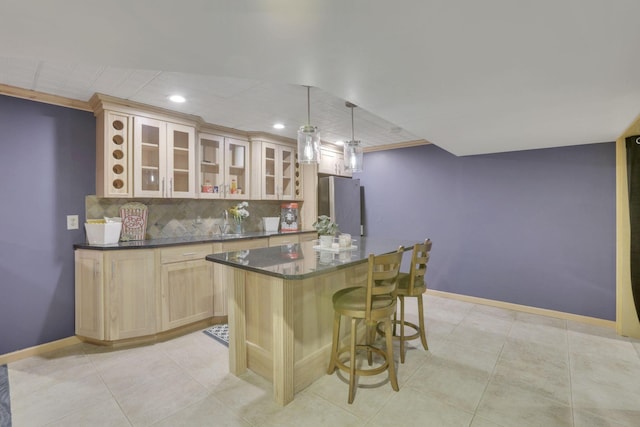 kitchen with baseboards, backsplash, freestanding refrigerator, and a kitchen breakfast bar