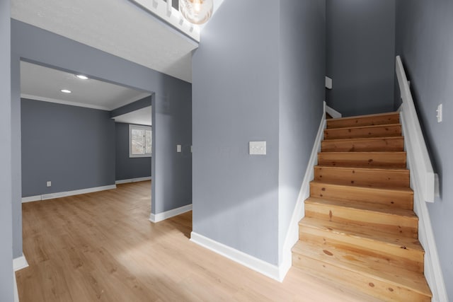 staircase with recessed lighting, baseboards, and wood finished floors