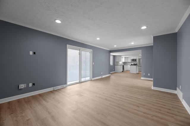 unfurnished living room featuring light wood finished floors, a textured ceiling, baseboards, and ornamental molding