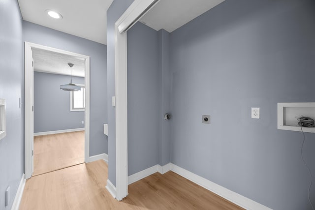 clothes washing area featuring hookup for a washing machine, hookup for an electric dryer, light wood-type flooring, and baseboards