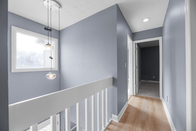 corridor featuring baseboards and wood finished floors